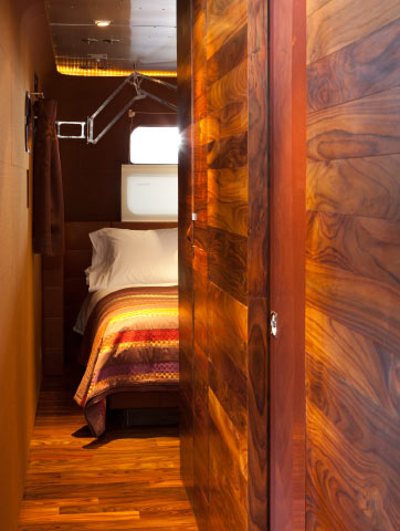 Floors and wall panels of reclaimed rosewood create a warm counterpoint to the trailers metal exterior. Missoni blanket from Pat McGann.